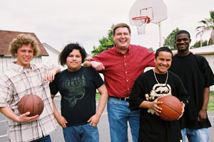 Adult with some boys holding basketballs.