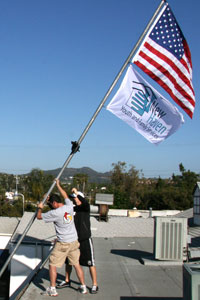Staff member raising flags.